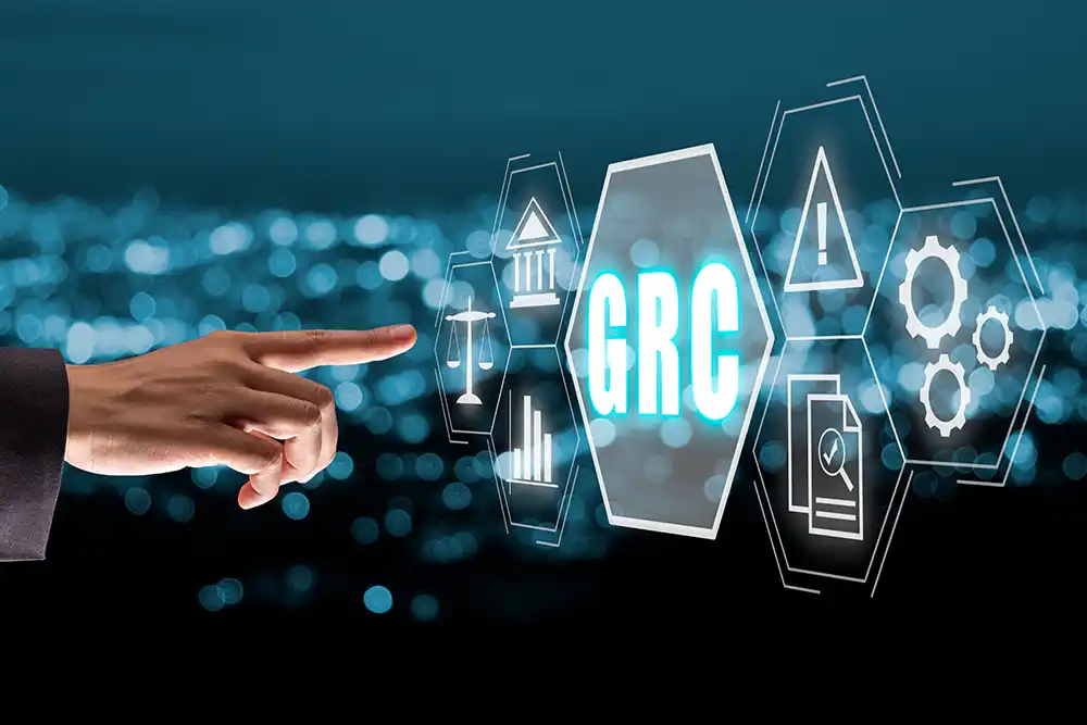 Hand pointing to IT computer screen  with  GRC - Governance Risk Compliance service